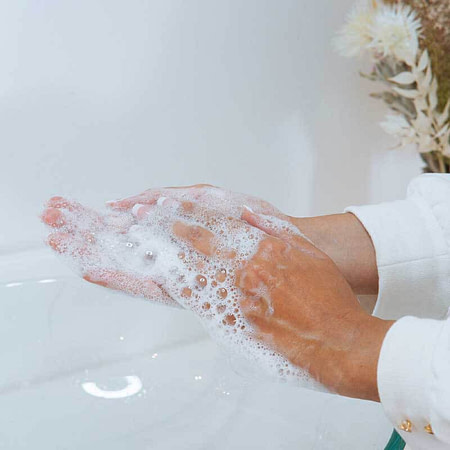 Frau schäumt Reinigungsgel in ihren Händen auf